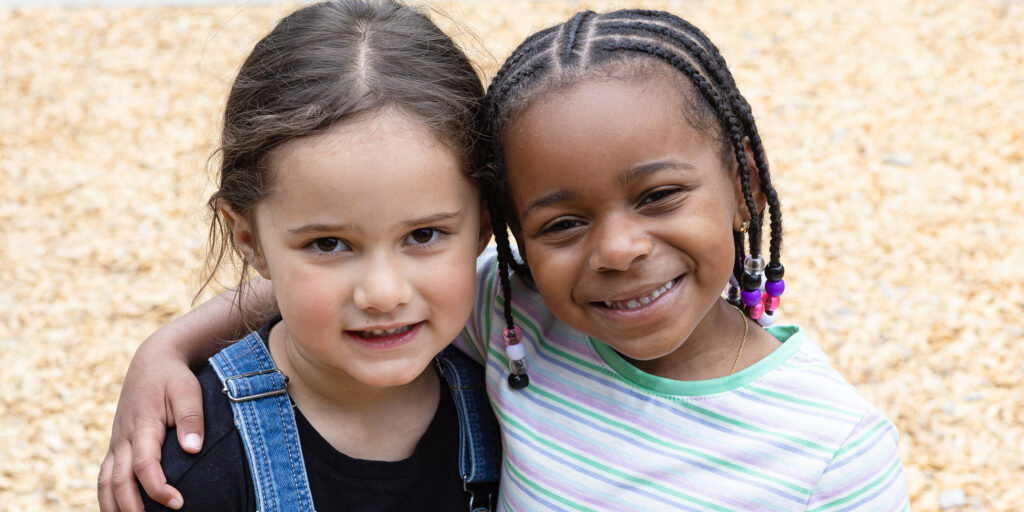 Two little girls smiling at the camera.