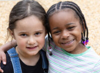 Two little girls smiling at the camera.