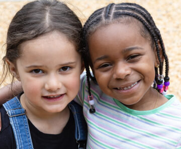 Two little girls smiling at the camera.